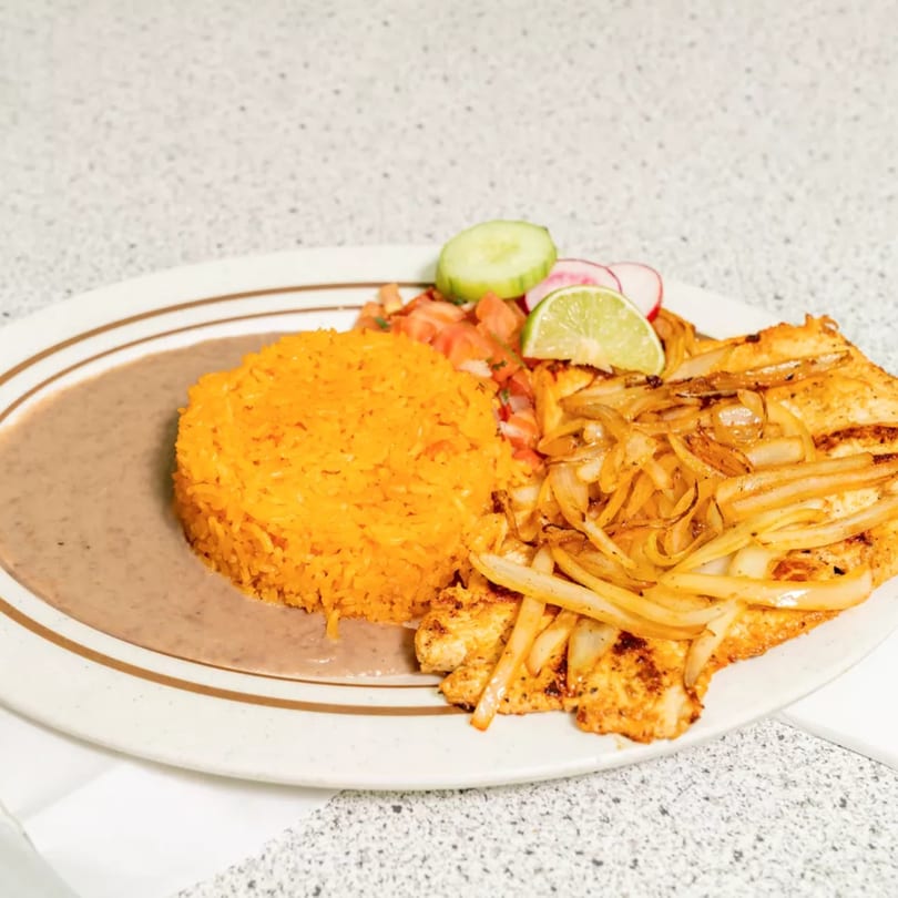 Grilled chicken with sautéed onions, orange rice, refried beans, pico de gallo, and lime.